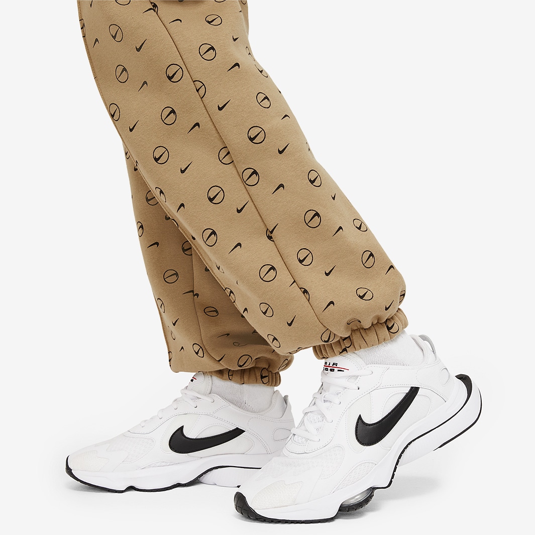 nike all over logo print joggers in camel